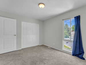 Unfurnished bedroom with carpet floors, a closet, and baseboards