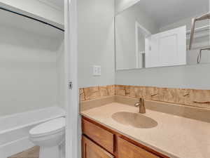 Bathroom featuring toilet, vanity, and tile patterned floors