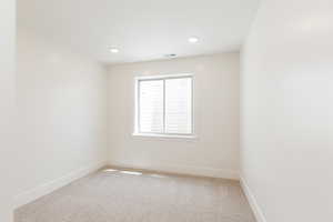 Empty room with baseboards, light carpet, and recessed lighting