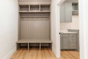 Mudroom with light wood finished floors and baseboards