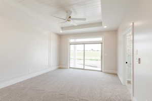 Unfurnished room with light carpet, ceiling fan, baseboards, and wood ceiling