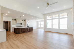 Unfurnished living room with light wood-style floors, a sink, baseboards, a ceiling fan, and recessed lighting