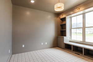 Spare room featuring a chandelier, baseboards, and built in shelves