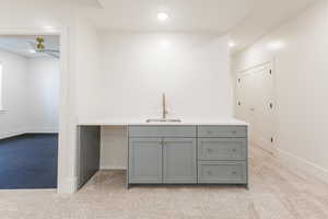 Bar featuring a sink, light carpet, a ceiling fan, baseboards, and recessed lighting