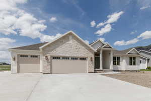 View of front facade with a garage, concrete driveway, and a shingled roof