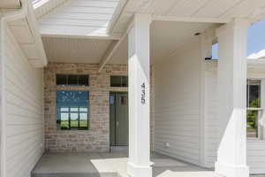Property entrance featuring stone siding and a porch