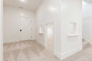 Hallway with carpet and baseboards