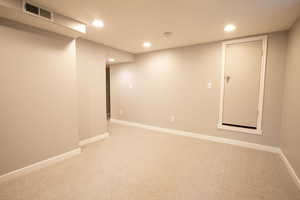 Finished below grade area featuring light carpet, recessed lighting, and baseboards