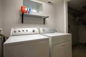 Laundry room with washing machine and clothes dryer and dark tile patterned flooring