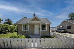 Bungalow-style house with a chimney and roof with shingles