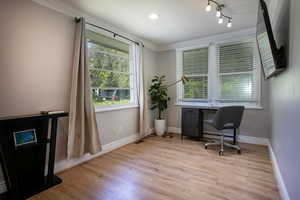 Office with crown molding, baseboards, and wood finished floors