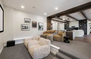 Living room with dark colored carpet, recessed lighting, beamed ceiling, and baseboards