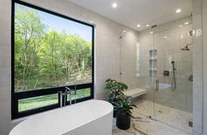 Full bathroom featuring a freestanding bath, a stall shower, marble finish flooring, and recessed lighting