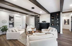 Living area with baseboards, stairs, dark wood-type flooring, beam ceiling, and a glass covered fireplace