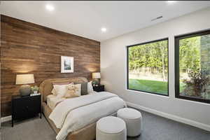 Bedroom with wooden walls, multiple windows, baseboards, recessed lighting, and carpet flooring