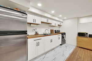 Brand New basement kitchen with butcher block counters, new cabinets, new appliances, new floors and can lighting