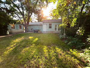 Rear view of property featuring a yard, french doors, and cooling unit