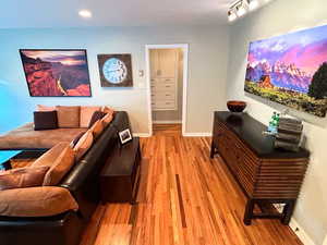 Living room featuring light wood-style flooring, baseboards, and recessed lighting