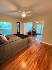 Bedroom with wood finished floors, a ceiling fan, and baseboards