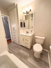 Full bathroom with toilet, vanity, a chandelier, and decorative backsplash