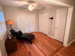 Sitting room with wood finished floors, ceiling fan, and baseboards