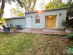 Rear view of house with a yard and a patio area