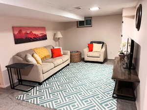 Living area featuring carpet flooring and baseboards