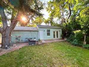 Back of house with french doors, a yard, and a patio