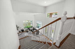 Staircase featuring plenty of natural light, wood finished floors, recessed lighting, and a towering ceiling.