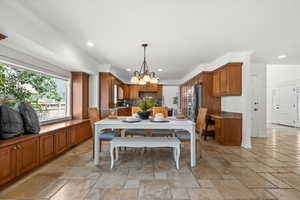 Kitchen dining with stone heated flooring, recessed lighting, a chandelier.
