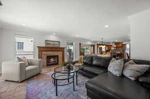 Living area with recessed lighting, crown molding, a premium fireplace, and stone tile flooring.