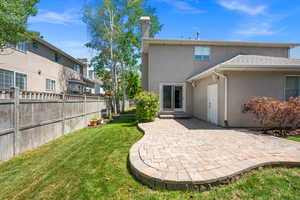 Back of house featuring stucco siding, a patio, and a chimney