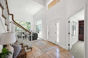 Foyer with stairway, a towering ceiling and stone flooring