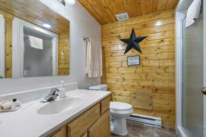 Bathroom with a baseboard heating unit, vanity, toilet, wood ceiling, and a shower stall