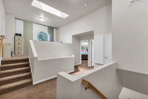 Staircase featuring carpet, a skylight, and baseboards