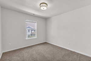 Carpeted spare room with baseboards