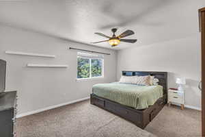 Carpeted bedroom with baseboards and a ceiling fan