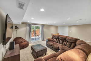 Living area with carpet flooring, recessed lighting, and baseboards
