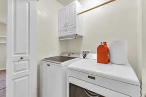 Laundry area with cabinet space, independent washer and dryer, and carpet