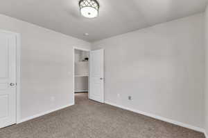 Unfurnished bedroom featuring carpet flooring and baseboards