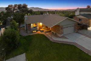 View of front of home with a garage, a chimney, a mountain view, driveway, and roof with shingles