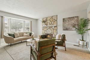 Carpeted living room with a fireplace and a textured ceiling