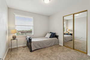Bedroom featuring light carpet and a closet