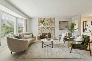 Sitting room featuring a stone fireplace, a textured ceiling, and carpet floors