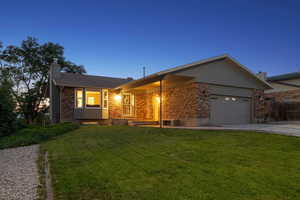 Ranch-style home with brick siding, a chimney, a garage, and concrete driveway