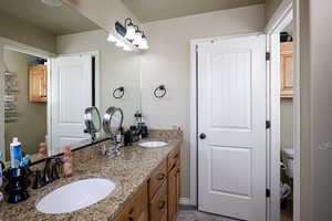 Full bath with toilet and double vanity
