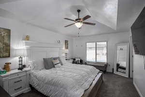 Bedroom featuring dark colored carpet, a ceiling fan, and baseboards