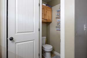 Bathroom featuring toilet, baseboards, and tile patterned flooring