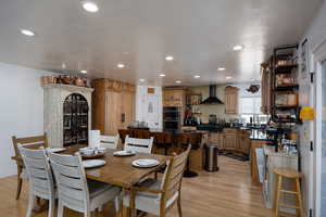 Dining room with light wood finished floors, recessed lighting, and a textured ceiling
