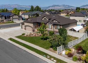 View of front facade with a residential view, driveway, stucco siding, and a mountain view
